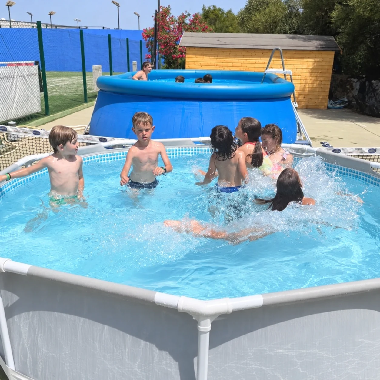 Niños participando en actividades de agua durante el campus de verano